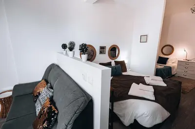 a bedroom with a large bed and a couch at Casa Branca Apartments by TrIp2Portugal in Funchal