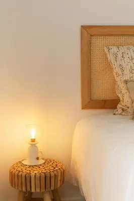a candle on a table next to a bed at Nōhō house in Carrapateira