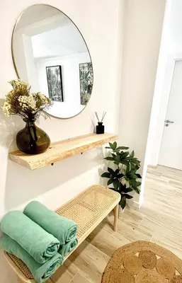 a bathroom with a mirror and a bench with towels at Nōhō house in Carrapateira