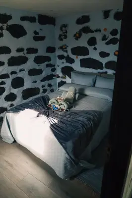 a bed in a bedroom with a cow print wall at Los Amantes de la naturaleza. in Salão