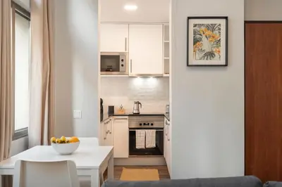 a kitchen and dining room with a white table and chairs at Alegria Flat by An Island Apart in Funchal