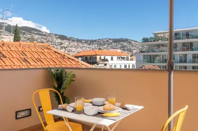 a table with food on it on a balcony at Alegria Flat by An Island Apart in Funchal