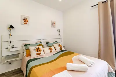 a bedroom with a bed with colorful sheets and pillows at Casa Sabino in Almádena
