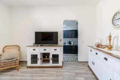 a living room with a television on a white cabinet at Casa Sabino in Almádena
