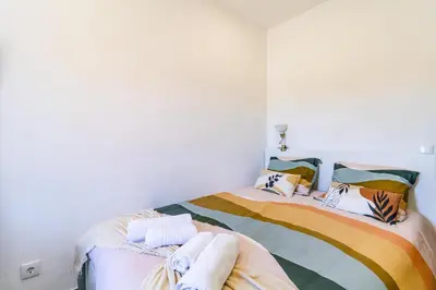 a bedroom with a bed with colorful blankets and pillows at Casa Sabino in Almádena