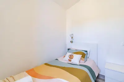 a small bedroom with a bed with colorful pillows at Casa Sabino in Almádena