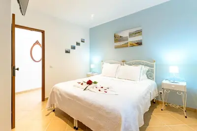 a blue bedroom with a bed with flowers on it at Bela casa na Costa Vicentina in Aljezur