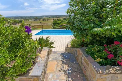 a swimming pool in a garden with flowers at Bela casa na Costa Vicentina in Aljezur