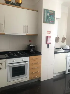 a kitchen with white cabinets and a stove top oven at Ocean Garden in Caniço