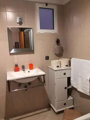 a bathroom with a white sink and a mirror at Ocean Garden in Caniço