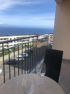 two wine glasses sitting on a table on a balcony at Ocean Garden in Caniço