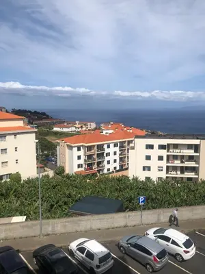 a parking lot with cars parked in front of buildings at Ocean Garden in Caniço