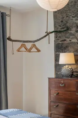 a bedroom with a bed and a lamp on a dresser at Casinha dos Canhas by An Island Apart in Ponta do Sol