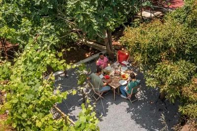 a group of people sitting around a table in a garden at Casinha dos Canhas by An Island Apart in Ponta do Sol