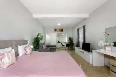 a bedroom with a pink bed and a living room at Studio Home Away from Home in Caniçal