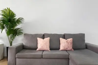 two pink pillows on a gray couch in a living room at Studio Home Away from Home in Caniçal