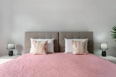 a bedroom with a pink bed with two lamps at Studio Home Away from Home in Caniçal