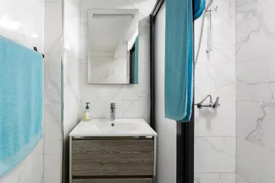 a bathroom with a sink and a mirror and blue towels at Studio Home Away from Home in Caniçal