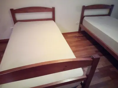 two twin beds in a room with wooden floors at Costa Lodges Funchal, Santa Cruz, private room in Santa Cruz
