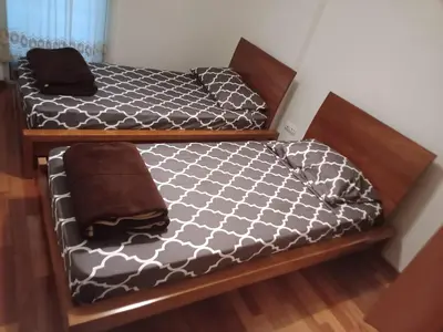 two beds with black and white comforter in a room at Costa Lodges Funchal, Santa Cruz, private room in Santa Cruz