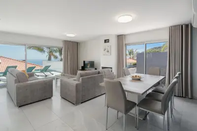 a dining room and living room with a table and chairs at OurMadeira - Arco Sun in Arco da Calheta