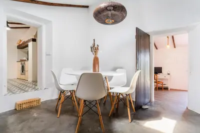 a white dining room with a white table and chairs at Casa Alfambras - Holiday Cottage in Aljezur by Lisbeyond in Aljezur