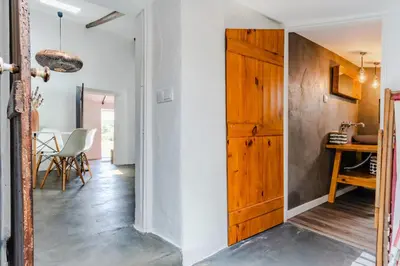 a hallway with a wooden door and a dining room at Casa Alfambras - Holiday Cottage in Aljezur by Lisbeyond in Aljezur