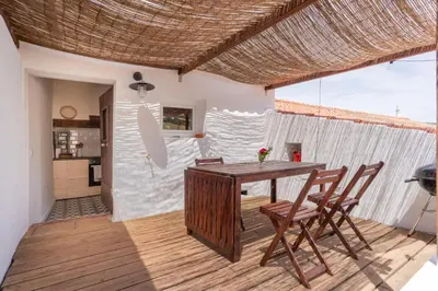 a dining room with a wooden table and chairs at Casa Alfambras - Holiday Cottage in Aljezur by Lisbeyond in Aljezur