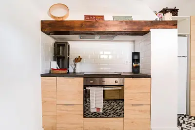 a kitchen with wooden cabinets and a counter top at Casa Alfambras - Holiday Cottage in Aljezur by Lisbeyond in Aljezur