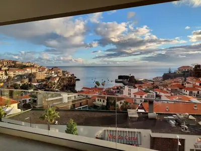 a view of a city and the ocean from a building at Stunning Lobos View in Câmara de Lobos