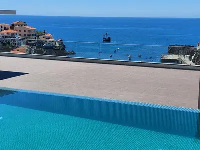 a swimming pool with a view of the ocean at Stunning Lobos View in Câmara de Lobos