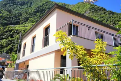 a house with a hill in the background at Casa da Portada in Seixal