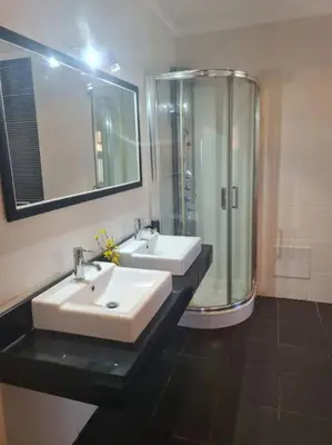 a bathroom with two sinks and a shower at Casa da Portada in Seixal