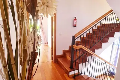 a hallway with a staircase with a vase of flowers at Casa da Portada in Seixal