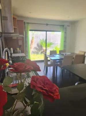 a vase with red roses on a table in a room at Casa da Portada in Seixal