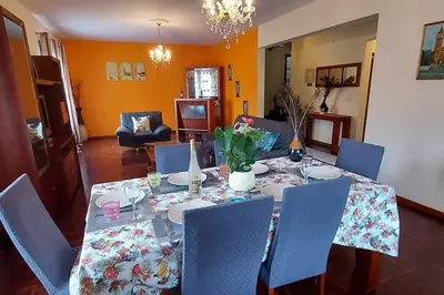 a dining room table with blue chairs and a table cloth at Gomes house in Ponta do Sol
