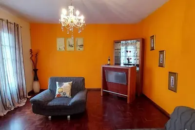 a living room with a chair and a television at Gomes house in Ponta do Sol