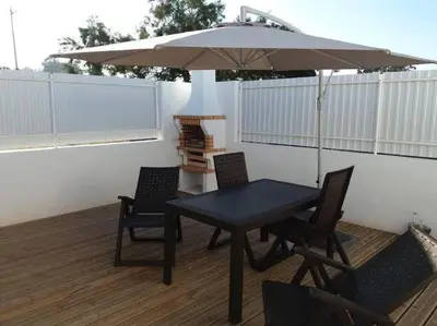 a table and chairs with an umbrella on a patio at Sunny Aljezur da Viana, (Aljezur, Costa Vicentina) in Aljezur