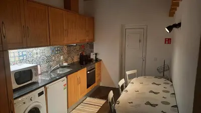 a small kitchen with a table and a microwave at Sunny Aljezur da Viana, (Aljezur, Costa Vicentina) in Aljezur