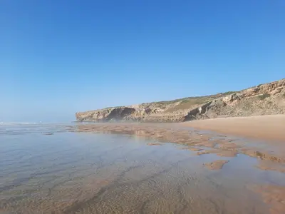 a sandy beach with rocks in the water at Sunny Aljezur da Viana, (Aljezur, Costa Vicentina) in Aljezur