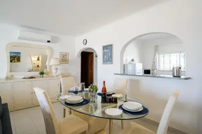 a dining room and kitchen with a table and chairs at Ramalhete panoramic view apartment in Luz