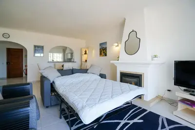 a bedroom with a bed and a tv and a fireplace at Ramalhete panoramic view apartment in Luz