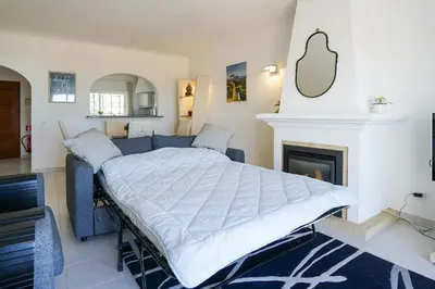 a bed in a room with a fireplace at Ramalhete panoramic view apartment in Luz