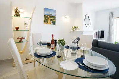 a dining room with a glass table and a couch at Ramalhete panoramic view apartment in Luz