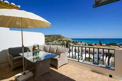 a balcony with a table and a view of the ocean at Ramalhete panoramic view apartment in Luz