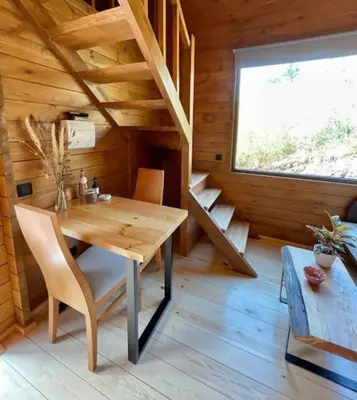 a wooden dining room with a table and a window at Mountain Eco Shelter 9 in Funchal