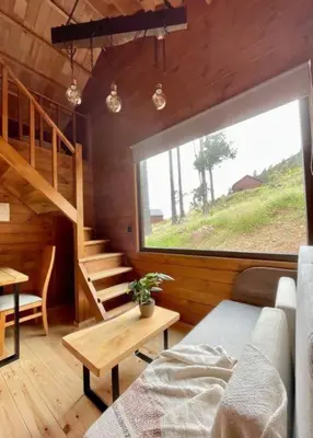 a room with a staircase and a living room with a couch at Mountain Eco Shelter 9 in Funchal