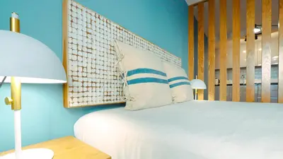 a bedroom with a bed with a wooden headboard at Marina Club Studio Traveller Hideaway in Funchal