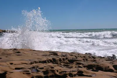 a person is jumping in the water at the beach at Lovely 1 Bedroom apartment in Praia da Luz in Luz