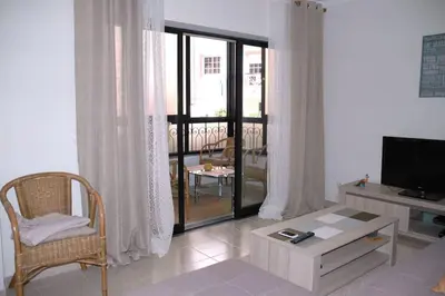 a living room with a television and a chair and a table at Lovely 1 Bedroom apartment in Praia da Luz in Luz